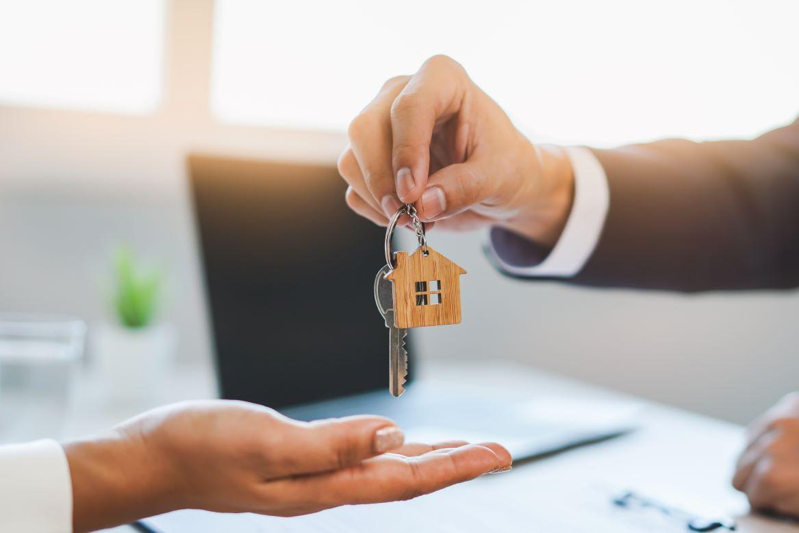 property owner giving house key to buyer<br />
