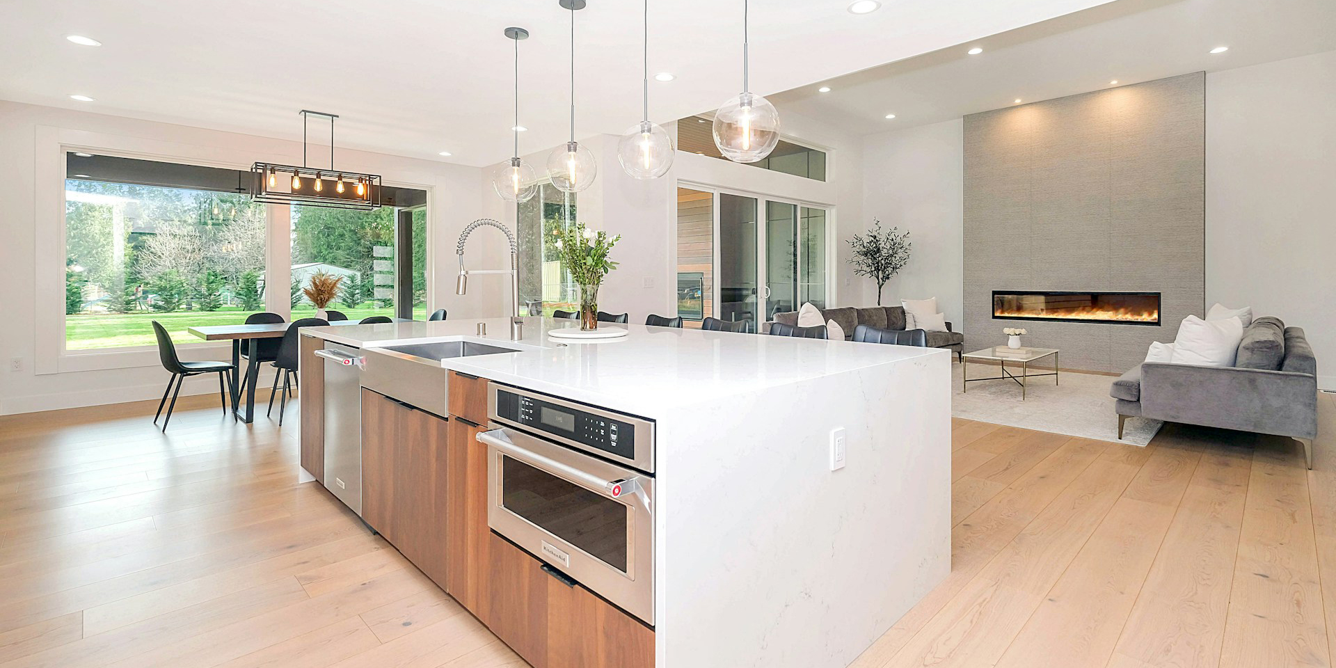 An ultra modern kitchen with waterfall quartz counter and pendant lighting.