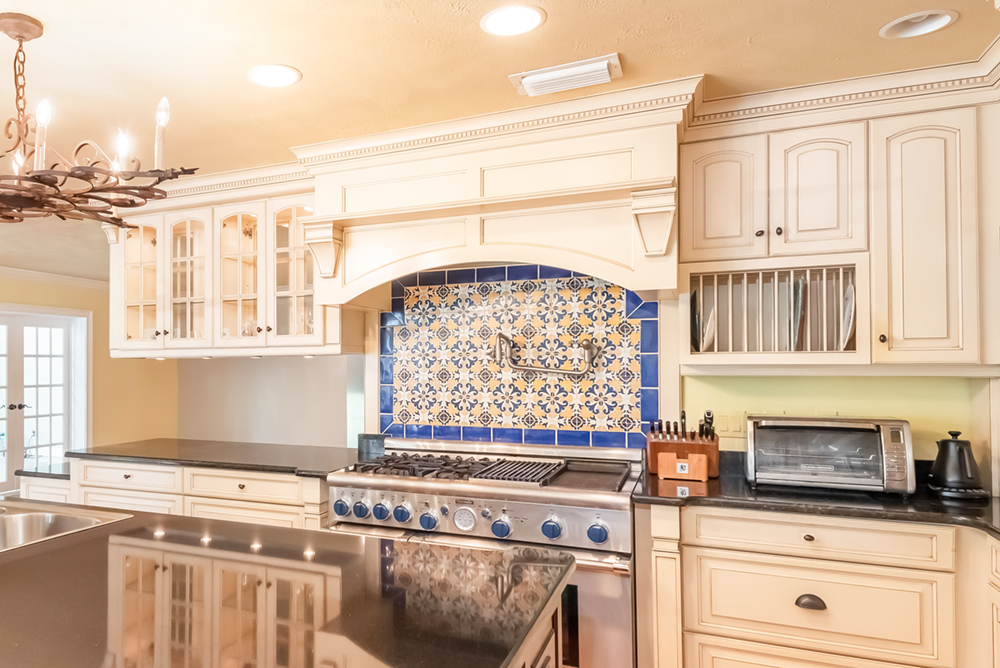 A luxury kitchen with beautifully tiled backsplash behind stove.