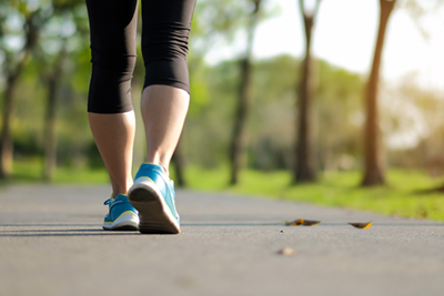 A woman on a jogging path at a park.