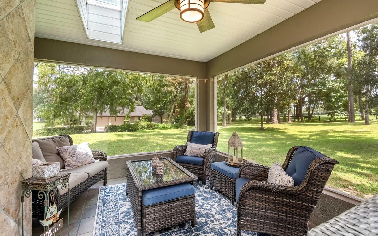 A shady lanai with ceiling fan and lots of room for seating.