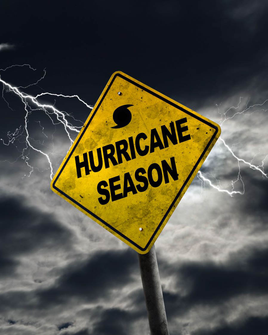 A sign reading hurricane season in front of a stormy sky