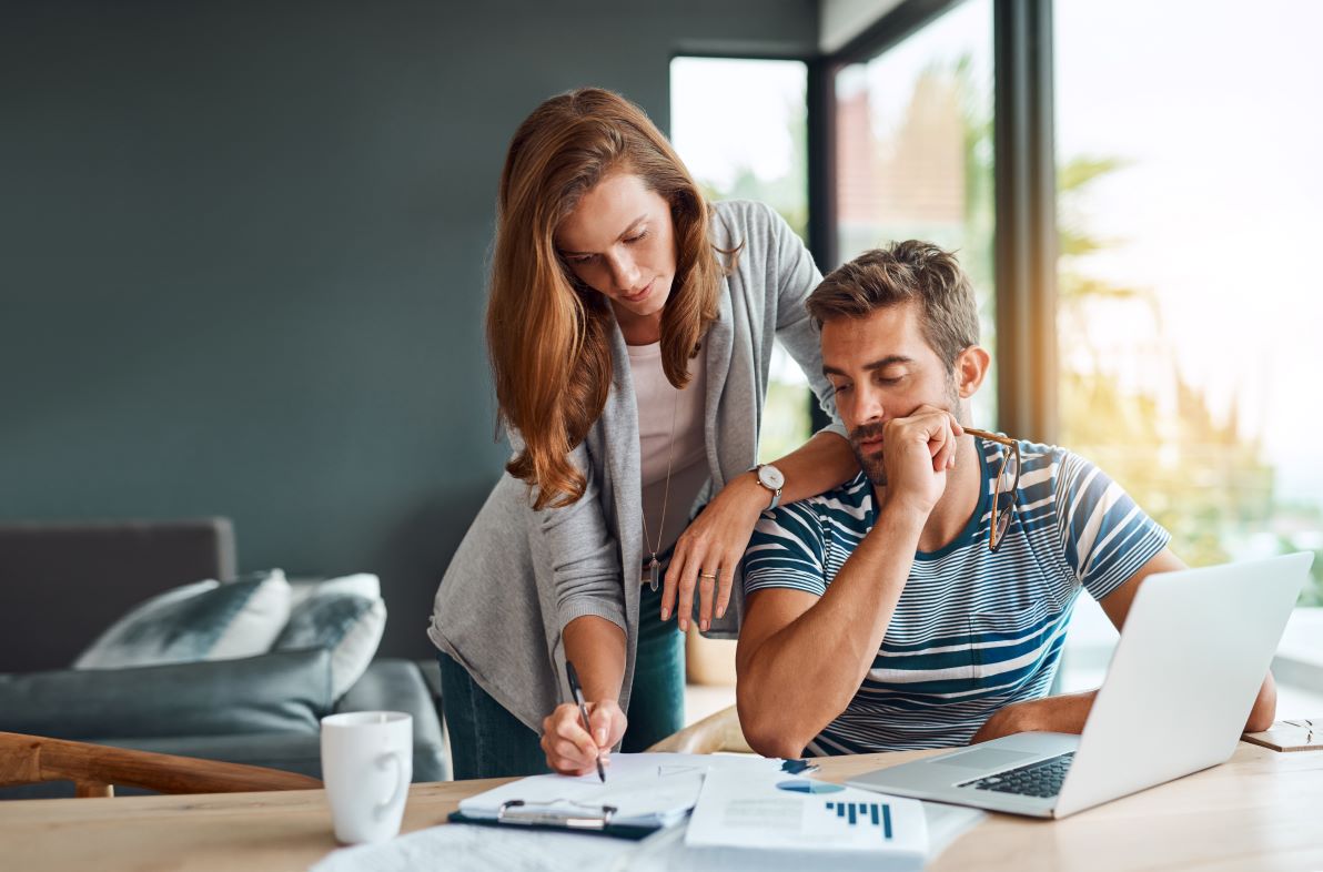 A couple using a laptop and working on paperwork