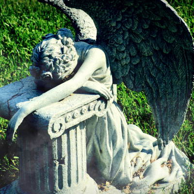 An eerie weeping angel in a cemetery